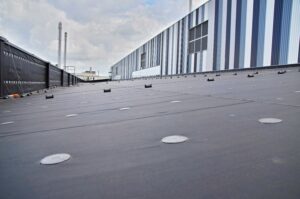 Neu abgedichtetes Flachdach mit Industriegebaeude im Hintergrund, Referenzprojekt Aluminiumwerk Grevenbroich von HDG Dachtechnik