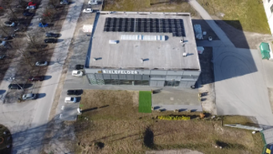 Luftaufnahme eines Flachdachs mit teilweiser Photovoltaikanlage, Referenzprojekt von HDG Dachtechnik