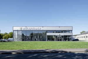 Frontalansicht eines Firmengebaeudes mit Glasfassade und Flachdach, Referenzprojekt von HDG Dachtechnik