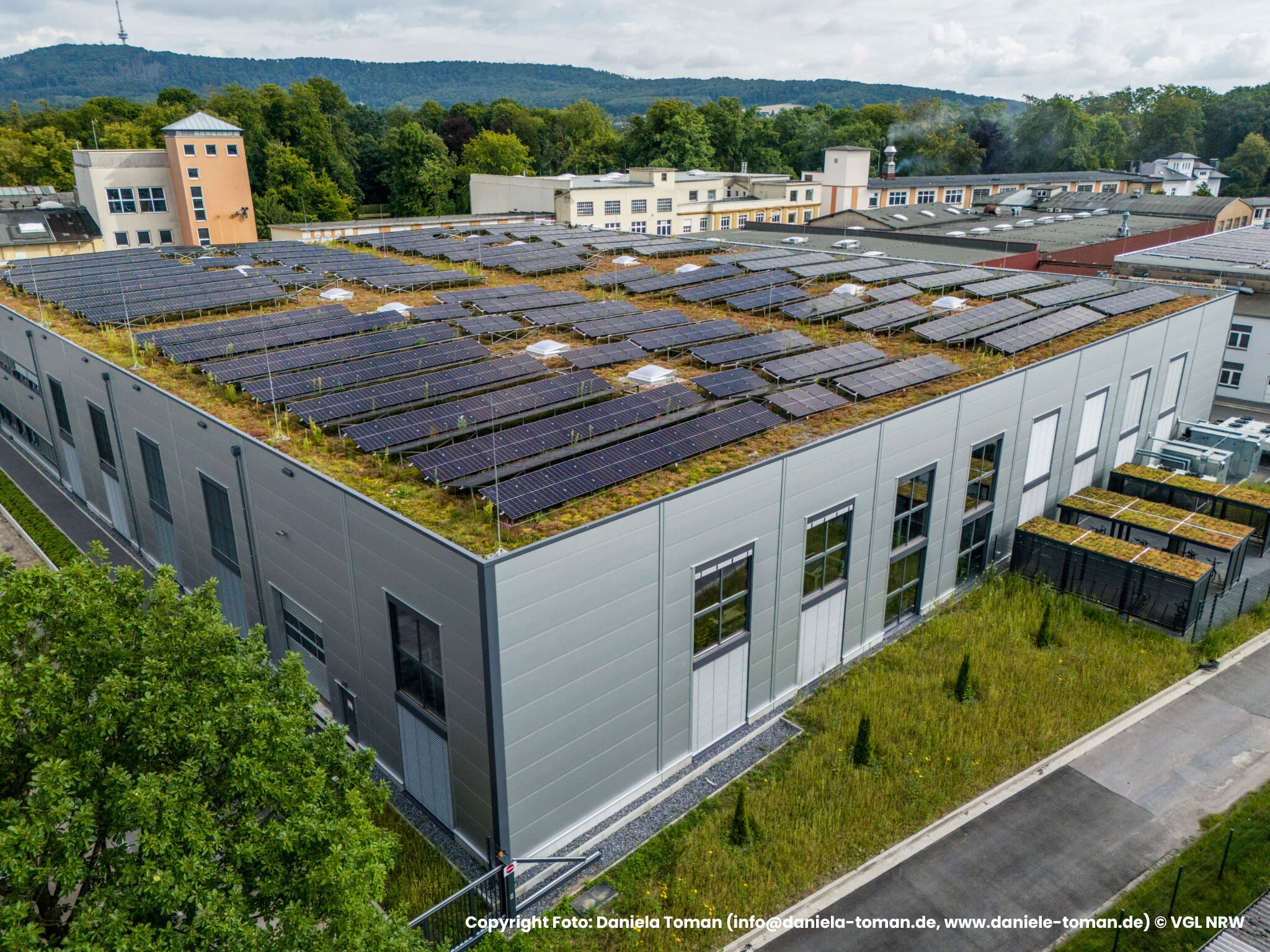 Luftaufnahme eines Gebaeudes mit begruentem Dach und Photovoltaikanlage, Referenzprojekt Moeller Real Estate von HDG Dachtechnik